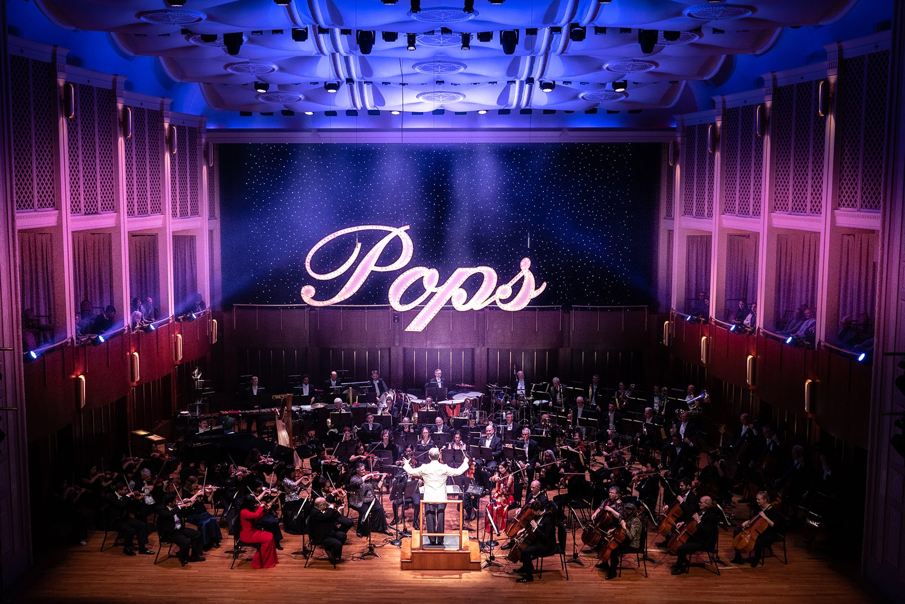 Conductor in front of the entire pops orchestra with dramatic lighting